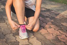 Imatge d'una dona cordant-se unes sabatilles esportives 