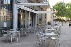 Imagen de mesas y sillas de la terraza de un bar