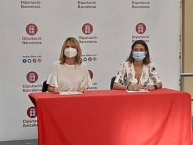 Foto de l'alcaldessa, Núria Parlon, i Lluïsa Moret de la Diputació de Barcelona signant el conveni 'Barris i comunitats: motors de transformació social'