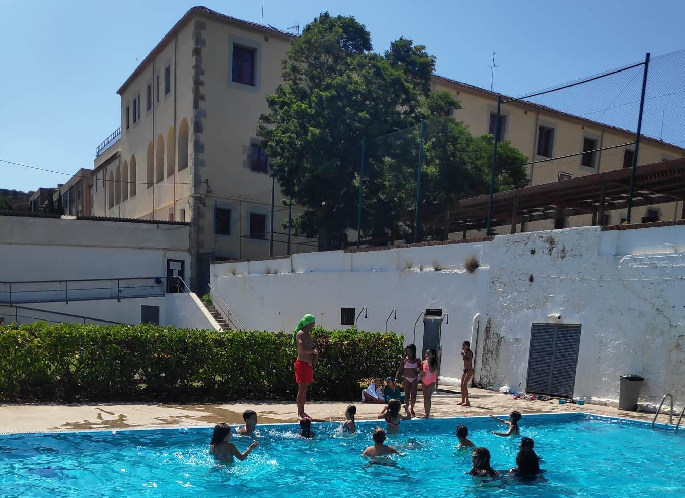 Colònies d'estiu Nens i nenes jugant a la piscina